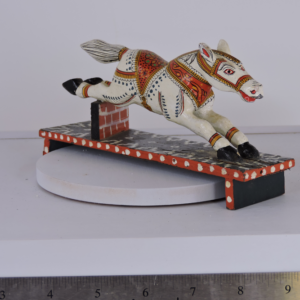 Hand-painted vintage Indian Kondapalli wooden horse leaping over a red brick wall