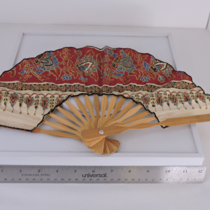 Vintage Indonesian batik folding fan featuring the red Buketan floral motif on a cream background with natural bamboo ribs.