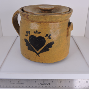 Hand-thrown mustard-yellow stoneware crock with hand-painted dark brown heart and feather motifs, asymmetrical loop and lug handles, including original lid.