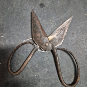 Antique hand-forged iron primitive shears with dark patina.