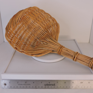 Vintage hand-woven rattan kitchen strainer and large scoop on a white background.